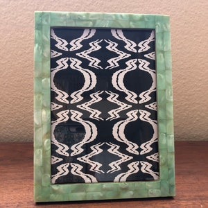 Green mother of pearl frame holds a 5 x 7 image