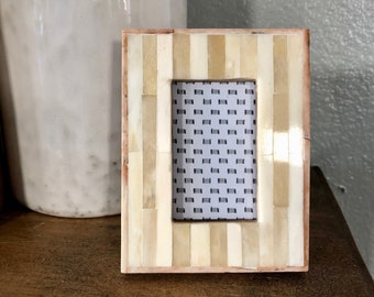 Vintage style beige 4 1/2 x 3 1/2” frame with ornate details holds a 1 3/4 x2 3/4” image