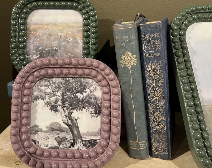 Lilac Bobbin Colored 5 1/4” x 5 1/4” resin frame holds a 4”x4” photo
