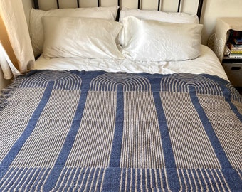 Woven  recycled cotton blend throw with pattern and fringe blue and tan in color. 60 x 50”.