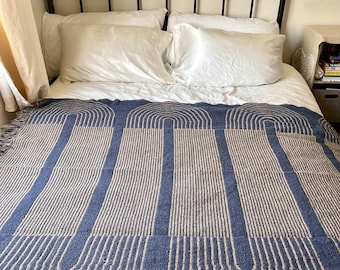 Woven  recycled cotton blend throw with pattern and fringe blue and tan in color. 60 x 50”.