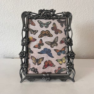 Victorian style silver frame with floral detailing holds approximately a 5 x 7 image