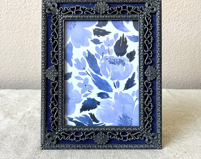 Vintage 9 1/2x7 1/2 silver and blue frame with ornate detailed border holds a 4 1/2"x6 1/2" image. Stand only