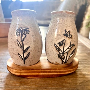 Salt and pepper shaker with floral detail and pinewood tray. Reactive glaze white and black and natural. Set of 3