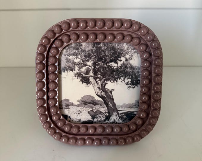 Lilac Bobbin Colored 5 1/4” x 5 1/4” resin frame holds a 4”x4” photo