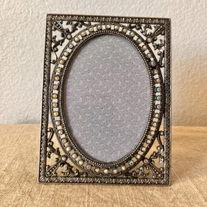 Vintage Art Deco style 6 1/2&quot;x5&quot;  silver frame with rhinestone detail with oval window holds a 3 1/4&quot; x 5 &quot; image
