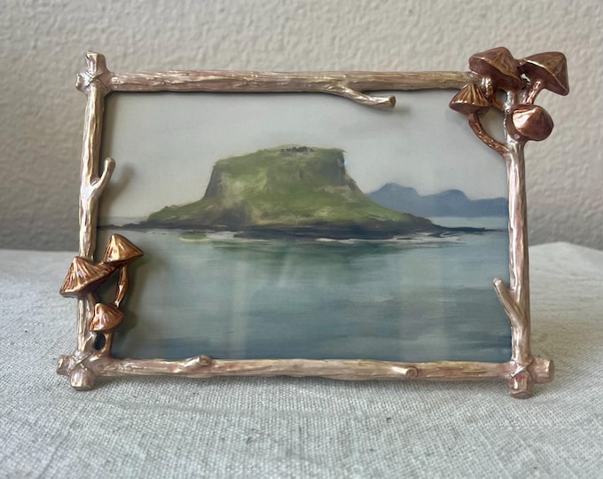 Gold enameled frame 7" x 5" with mushroom and branch details hold a 4x6 image