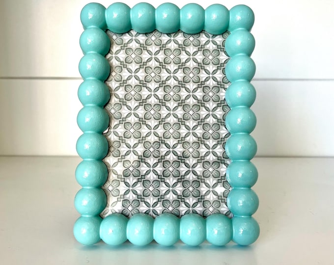 Vintage style light blue 7”x 5” hob knob frame holds a 3 1/2”x 5 1/4” photo