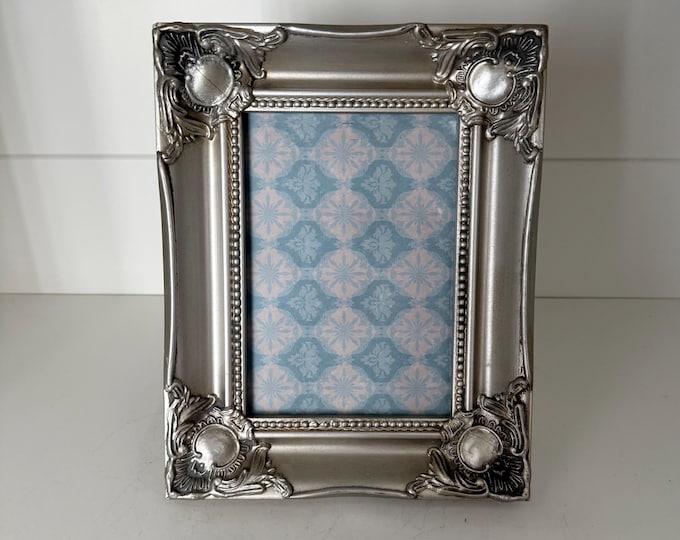Vintage victorian 7 1/2"x 9 1/2" silver frame holds a 4 1/2"x 6 1/2" image