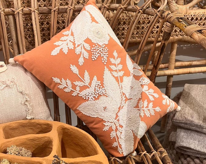 Orange colored pillow with cream and beige flower and leaf embroidered detailing 20"x14"