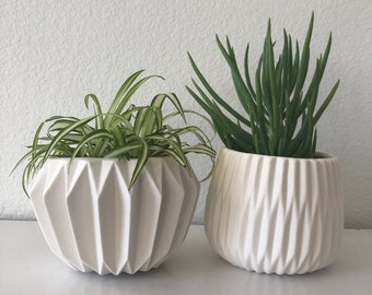 White fluted 6 1/4 inch round by 4 inch high matte white planter holds a 5 inch pot. No drain hole