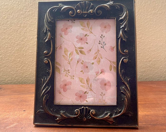 Vintage bronze colored wood frame with ornate detail holds a 5x7 measures out to be 10 "x 8".  Stand only