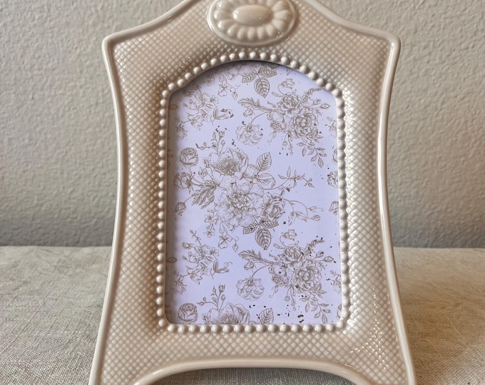 Vintage beige ceramic frame with floral detailing 9”x6” with a 5 1/2 by 3 3/4” inch oval window.