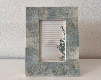 El marco blanco y aguamarina vintage de 8 3/4" x 6 3/4" sostiene una imagen de 3 1/2"x5". Solo soportes tanto horizontales como verticales.