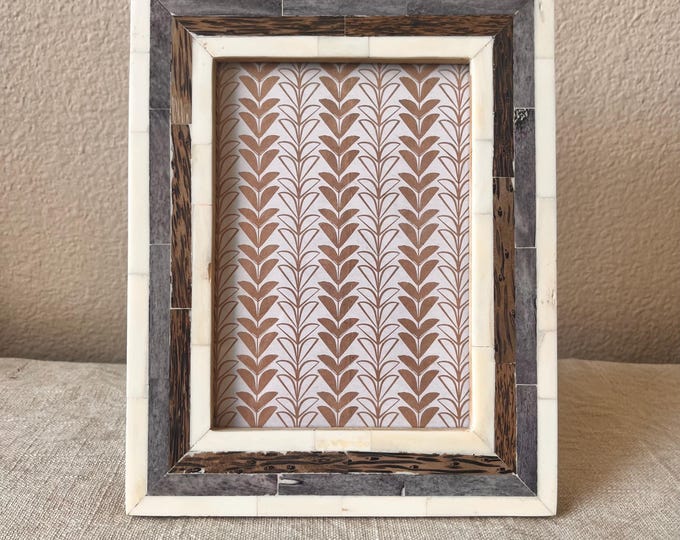 Vintage style blue brown and cream picture frame holds a 5x7 image