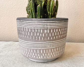 Terra-cotta planter 6 1/2"H x 8" W with embossed lines distressed brown color hold the 6 inch plant. No drain hole