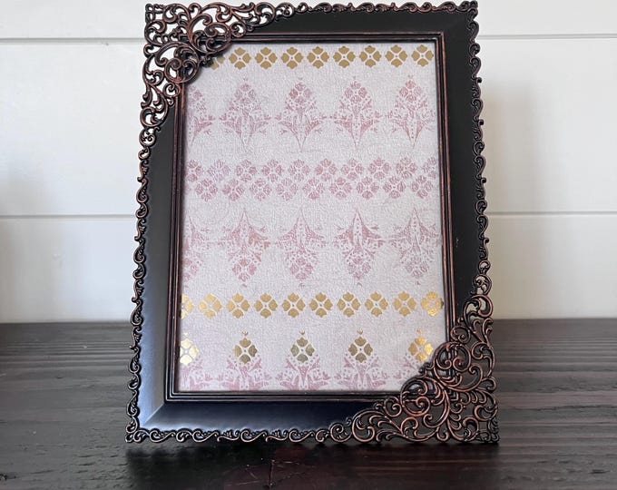 Vintage 8 1/2" x 6 1/2" bronze colored frame with lacy detail holds a 6 3/4" x 5" image. Stands and hangs in both directions