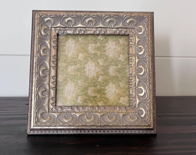 Vintage 6 1/4"x 6 1/4" gold square frame holds a 3 1/2” x 3 1/2” image. Hangs and stands.