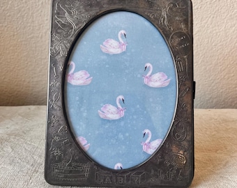 Vintage silver 8"x6 " oval babies first frame detailing holds  a 4 1/2” x 6 1/2” image. Has a photo album inside and holds 12-24 photos