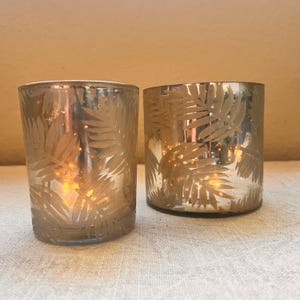 Gold mercury glass candle with leaf and snow motif comes in 2 sizes 4”x4” or 3”x4”
