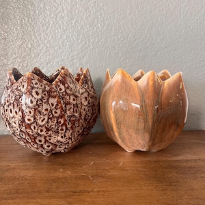 May include: Two ceramic flower-shaped planters. One is brown with white speckles and the other is a light brown with a marbled glaze.