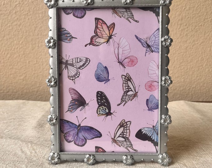 Vintage silver 5 1/2 x 7 1/2 frame holds a 4 1/2" x 6 1/2" image detailed with flowers and rhinestones