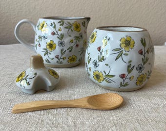 stoneware sugar and  creamer with floral design, reactive glaze, white and blue