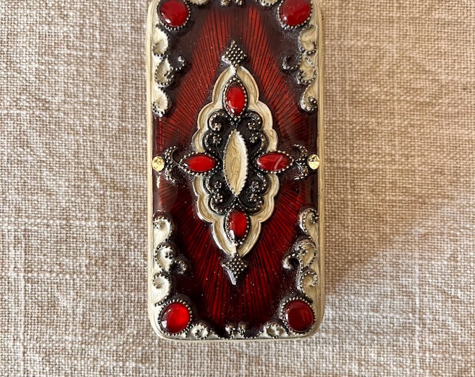 Vintage red and cream enameled jewelry box with rhinestone detailing and 3 small frames inside.