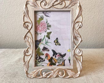 Art deco style 8"x6" white and gold frame holds a 3 1/2" x 5 1/2"image with leaf detailing