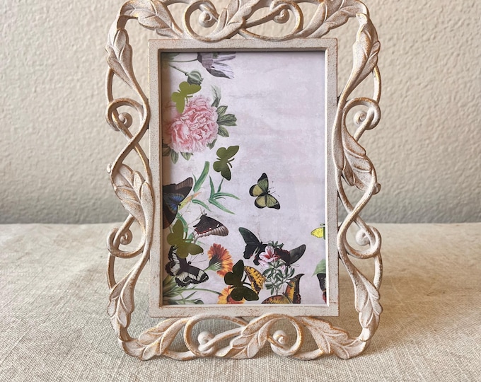 Art deco style 8"x6" white and gold frame holds a 3 1/2" x 5 1/2"image with leaf detailing