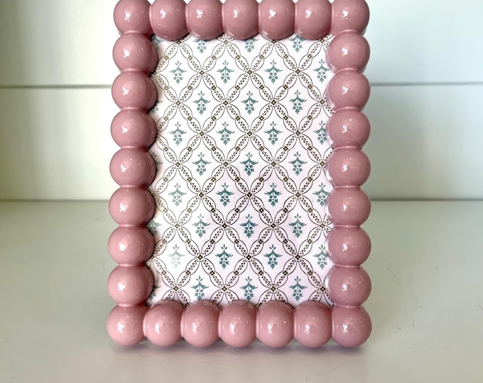 Vintage style light pink 7”x 5” hob knob frame holds a 3 1/2”x 5 1/4” photo