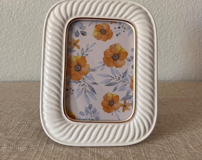Vintage 5 1/4" x 6 3/4" ceramic cream colored beveled frame with gold trim holds a 3" x 4 1/2" image