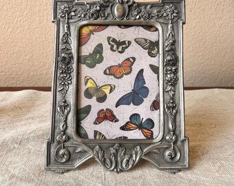Victorian style silver 7 1/2 "x 6"  holds a 3 1/2" x 5" image with the ornate floral detailing