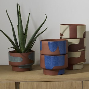 Modern terrakottaplanter med abstrakt målning. 18 x 14 cm. Finns i tre färger.