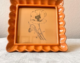 Vintage style orange colored 5 1/4” x 5 1/4” resin frame holda a 4”x4” photo