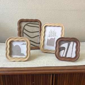 Wood frame with scalloped edges comes in two different colors. Can hang and stand both horizontal and vertical.
