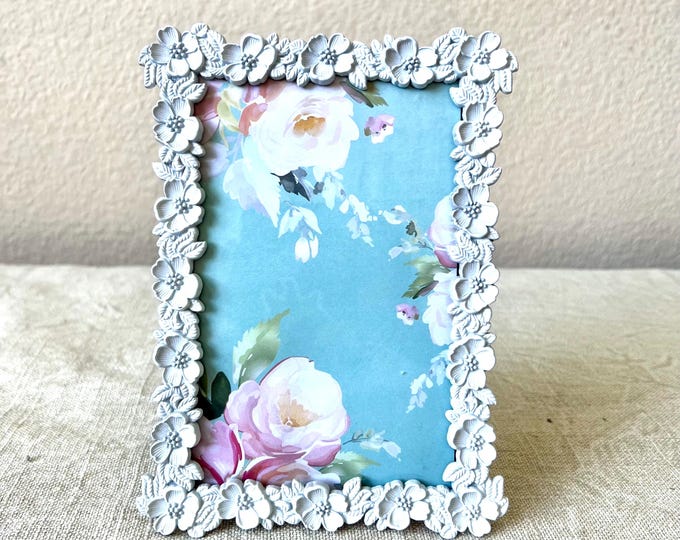 Vintage white 5" x 7" frame with flower details holds a  3 1/2 x 5 1/2 image