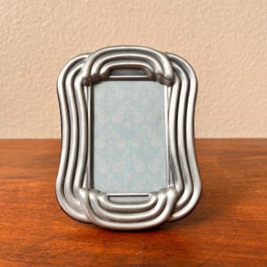 Vintage silver 3 1/2 x4 1/2 photo frame holds a 1 3/4&quot;x 2 3/4&quot; image. Stand only
