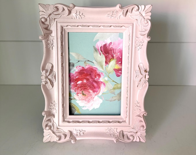 Vintage pink 6 1/2"x 8 1/2" frame with victorian style detailing holds a 3 1/2"x 5 1/2" image