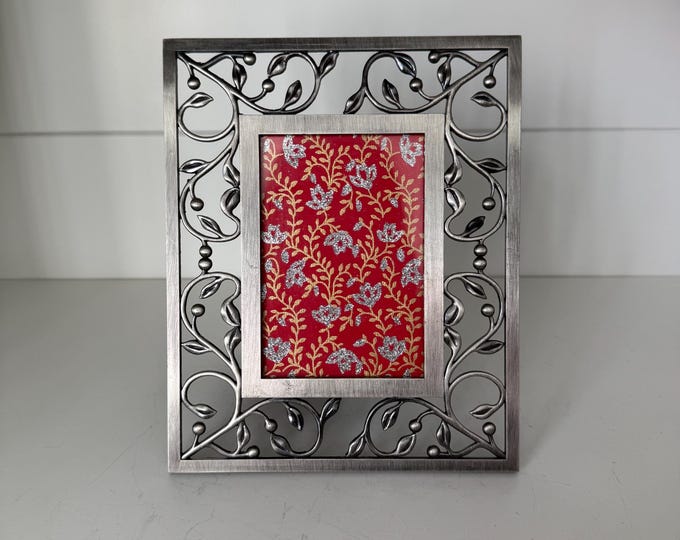 Vintage silver 6 1/2"x 8" frame with leaf detailing holds a 3"x 4 1/2" image