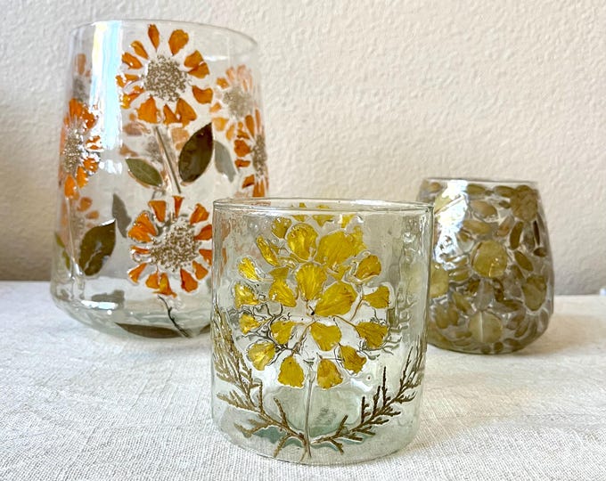 Glass candle holder debossed with leaf and petals in flower pattern