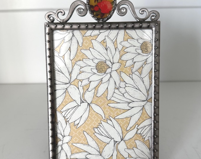 Vintage silver 4"x 6" frame with floral picture at the top holds a 3"x 5" image