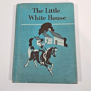 May include: Vintage book titled "The Little White House" with a teal cover. The cover features a black and white illustration of a person riding a horse in front of a house. The book's title is in white letters.