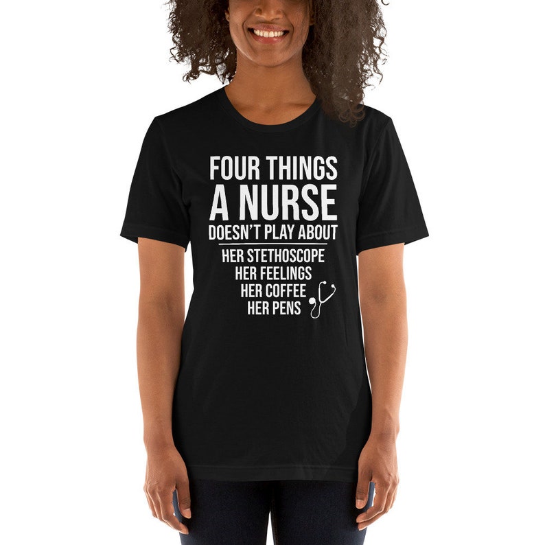 May include: Black t-shirt with white text that reads "Four things a nurse doesn't play about: her stethoscope, her feelings, her coffee, her pens". A small white stethoscope icon is next to the text.