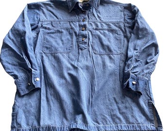 May include: A long-sleeved blue denim shirt featuring a pointed collar, a partial front button placket with metallic buttons, two chest pockets, and side slits at the hem. The shirt has buttoned cuffs and a classic medium-wash denim texture.