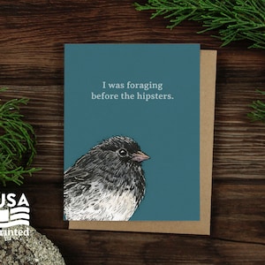 May include: A greeting card with a blue background and a black and white illustration of a bird. The text on the card reads "I was foraging before the hipsters."