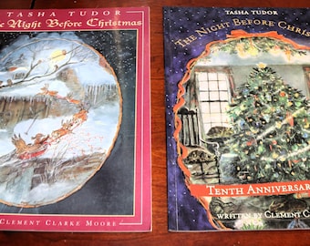 May include: Two copies of the book The Night Before Christmas by Tasha Tudor and Clement Clarke Moore. The left book features a winter sleigh scene in a red frame. The right book is a Tenth Anniversary Edition showing a decorated Christmas tree.