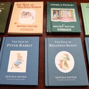 May include: A collection of eight vintage Beatrix Potter books. The titles include "The Tale of Jemima Puddle-Duck," "The Tale of Mrs. Tiggy-Winkle," "Ginger & Pickles," and "The Tale of Pigling Bland." The books are in various colors.