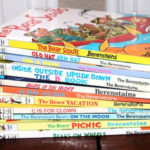 May include: A stack of ten children's books by Stan and Jan Berenstain, including titles like The Bear Scouts, Old Hat New Hat, The B Book, Bears in the Night, He Bear She Bear, The Bears' Vacation, C is for Clown, On the Moon, Picnic, and Wheels.