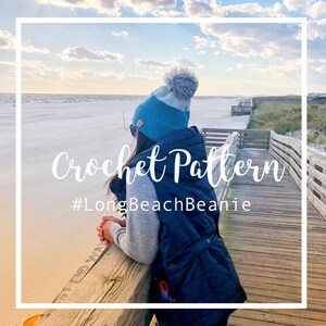 May include: A crochet beanie pattern with a blue and white striped beanie with a fluffy white pom pom. The beanie is worn by a person standing on a wooden boardwalk overlooking a beach. The text "Crochet Pattern #LongBeachBeanie" is superimposed on the image.